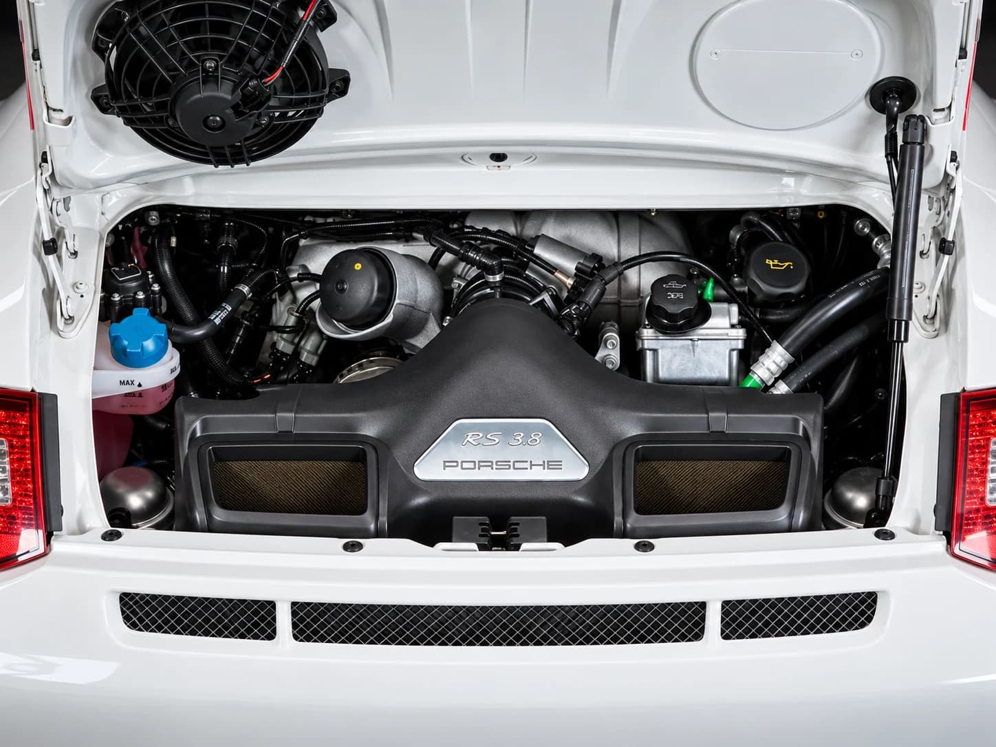 2010 Porsche 911 GT3 RS in Carrara White with Guards Red accents, engine detail, illustration in a dark studio setting